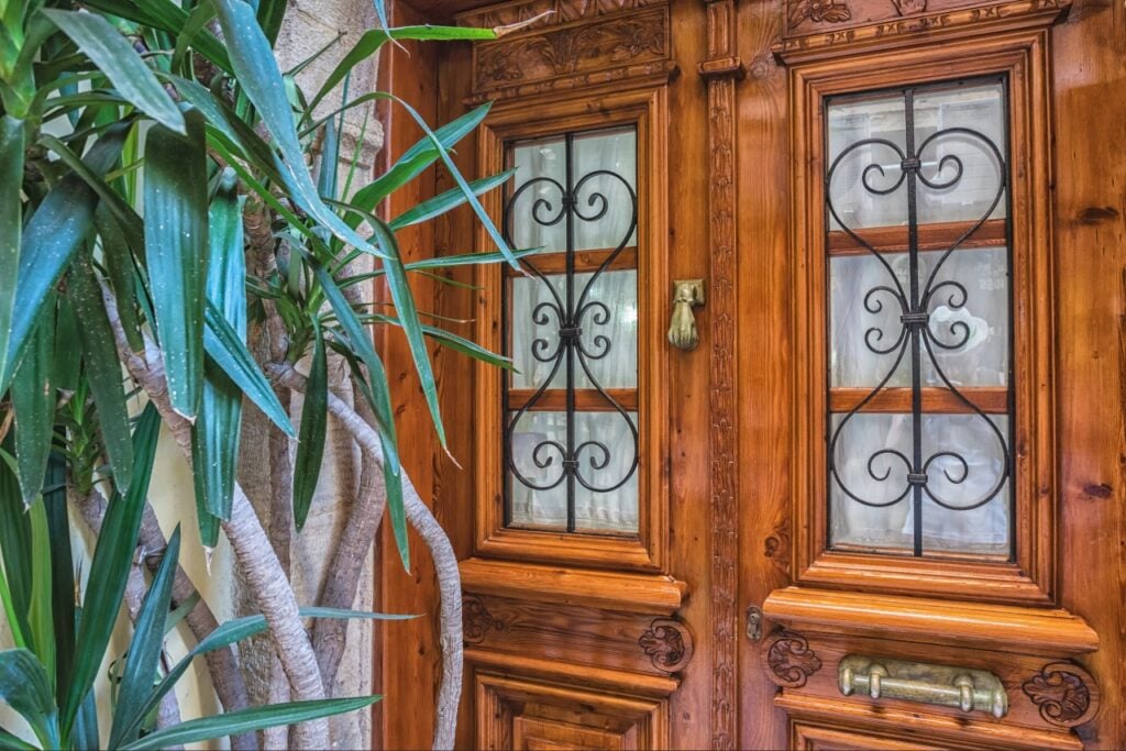 Wood front door being evaluated for refinishing or replacement in Sarasota